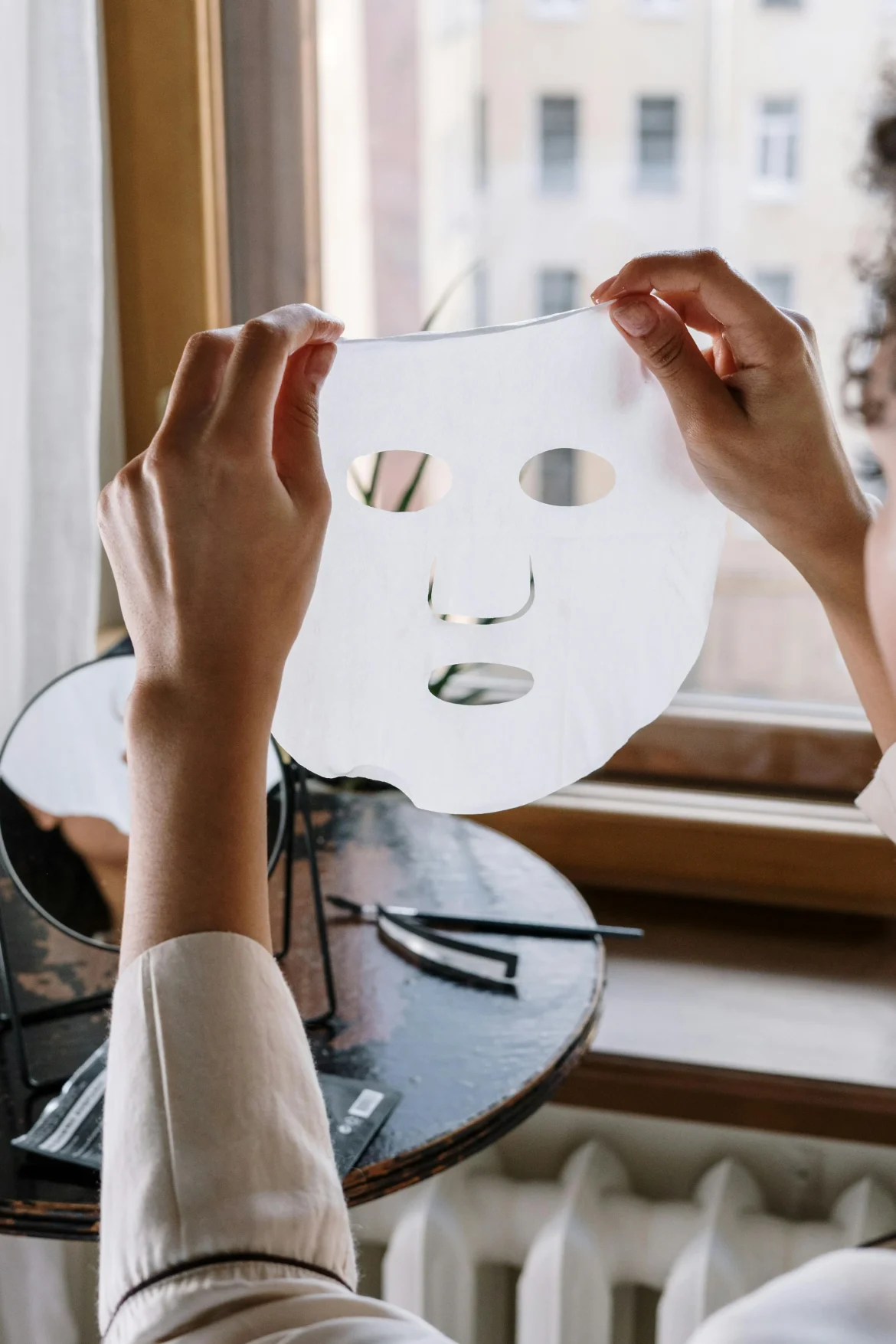 person holding a korean sheet mask near mirror – best korean sheet mask 2025