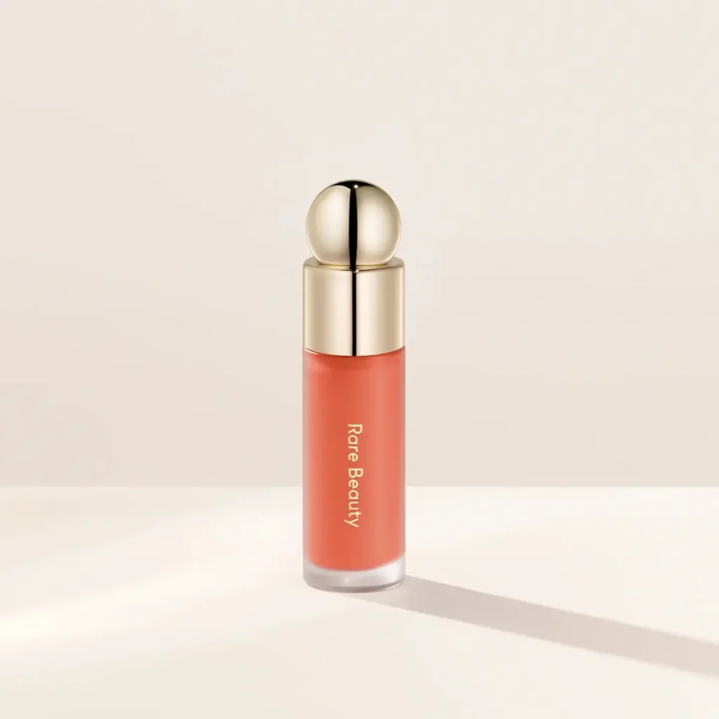 Rare Beauty Soft Pinch Liquid Blush in Joy, a muted coral liquid blush known for its long-lasting finish